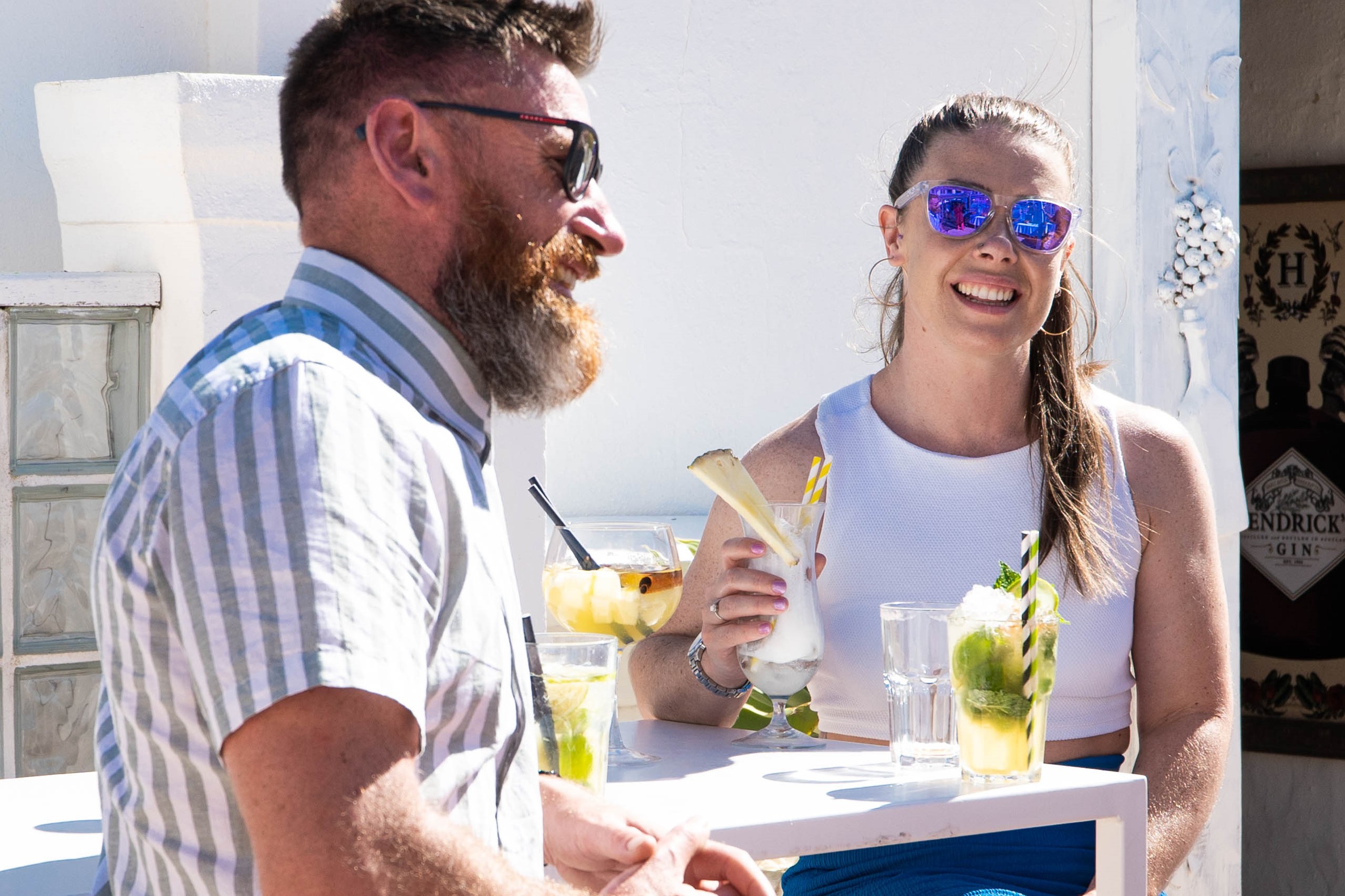 A man and woman sitting at a table with drinks